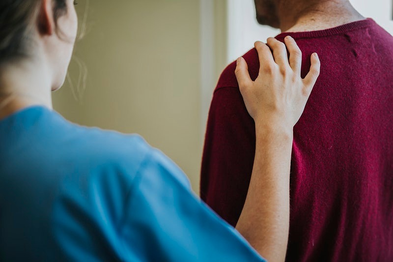 Female nurse touching a patients shoulder