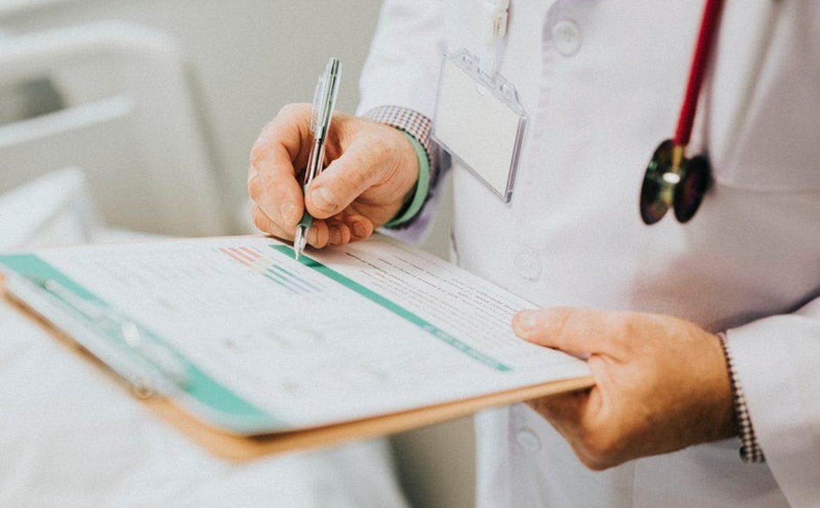 Physician noting down symptoms of a patient