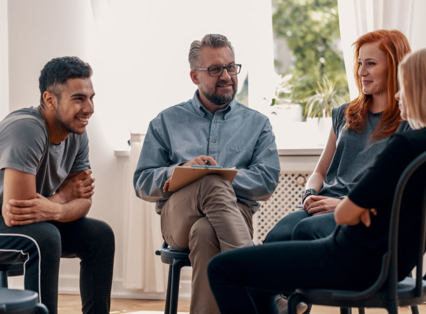 Smiling,Spanish,Man,Talking,To,His,Friends,During,Meeting,For