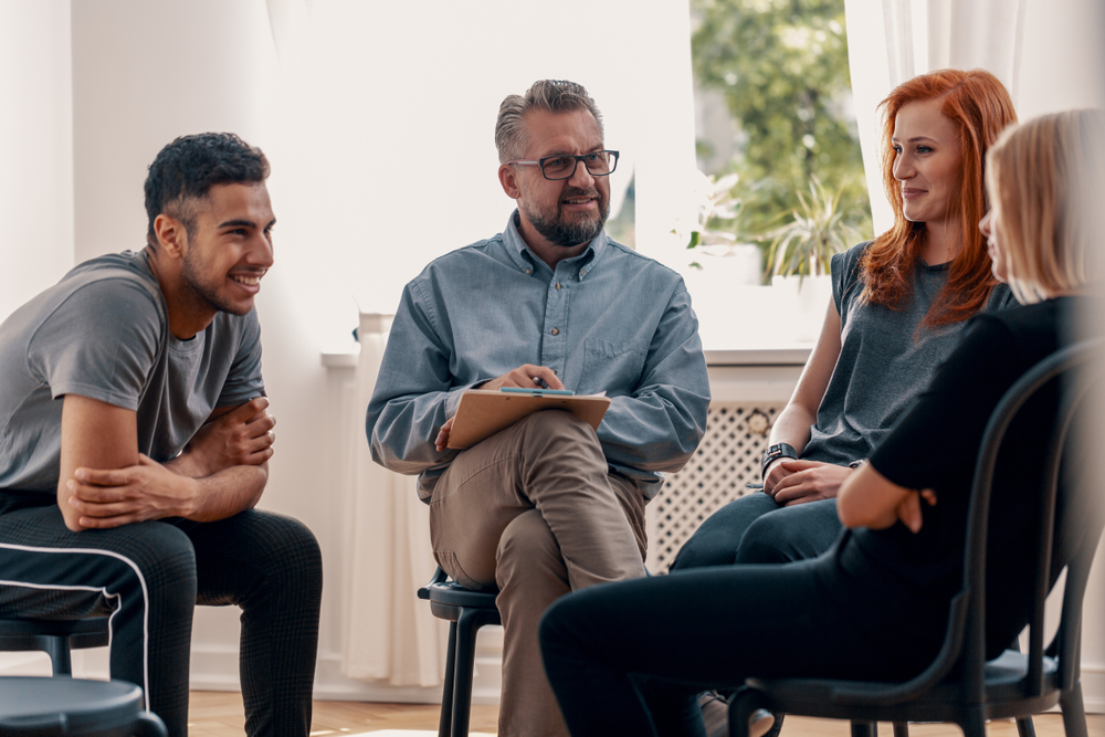 Smiling,Spanish,Man,Talking,To,His,Friends,During,Meeting,For