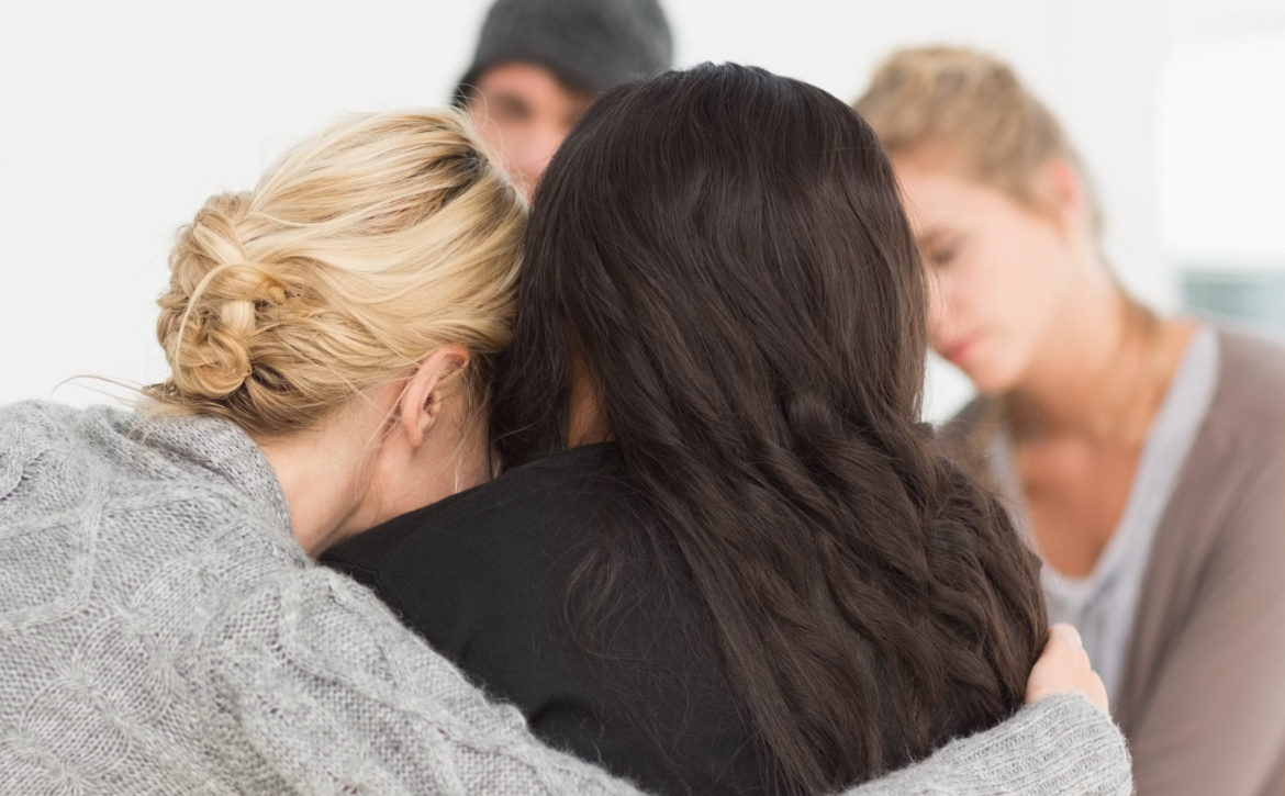 Women,Hugging,In,Rehab,Group,At,Therapy,Session