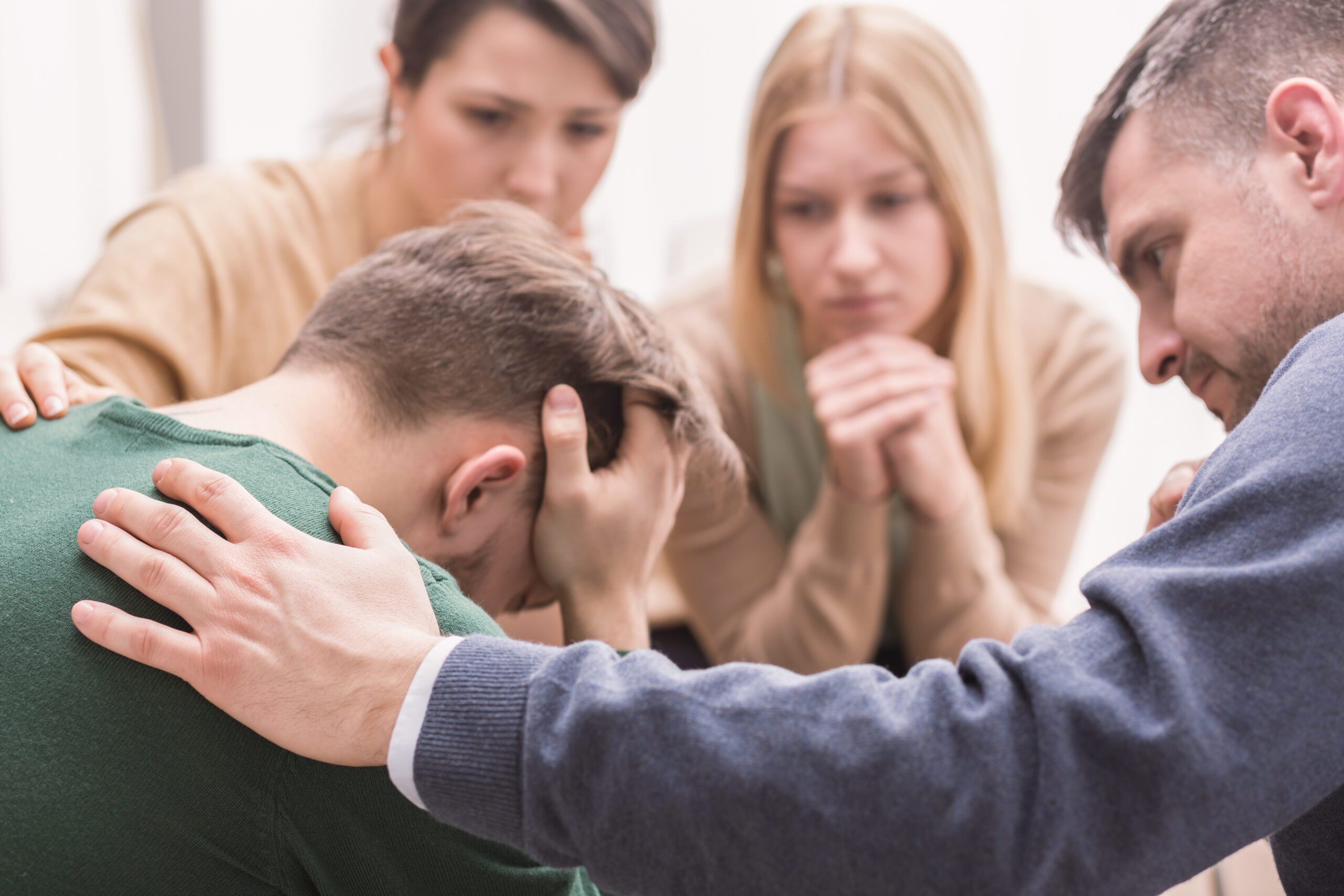 Close-up of a devastated young man holding his head in his hands