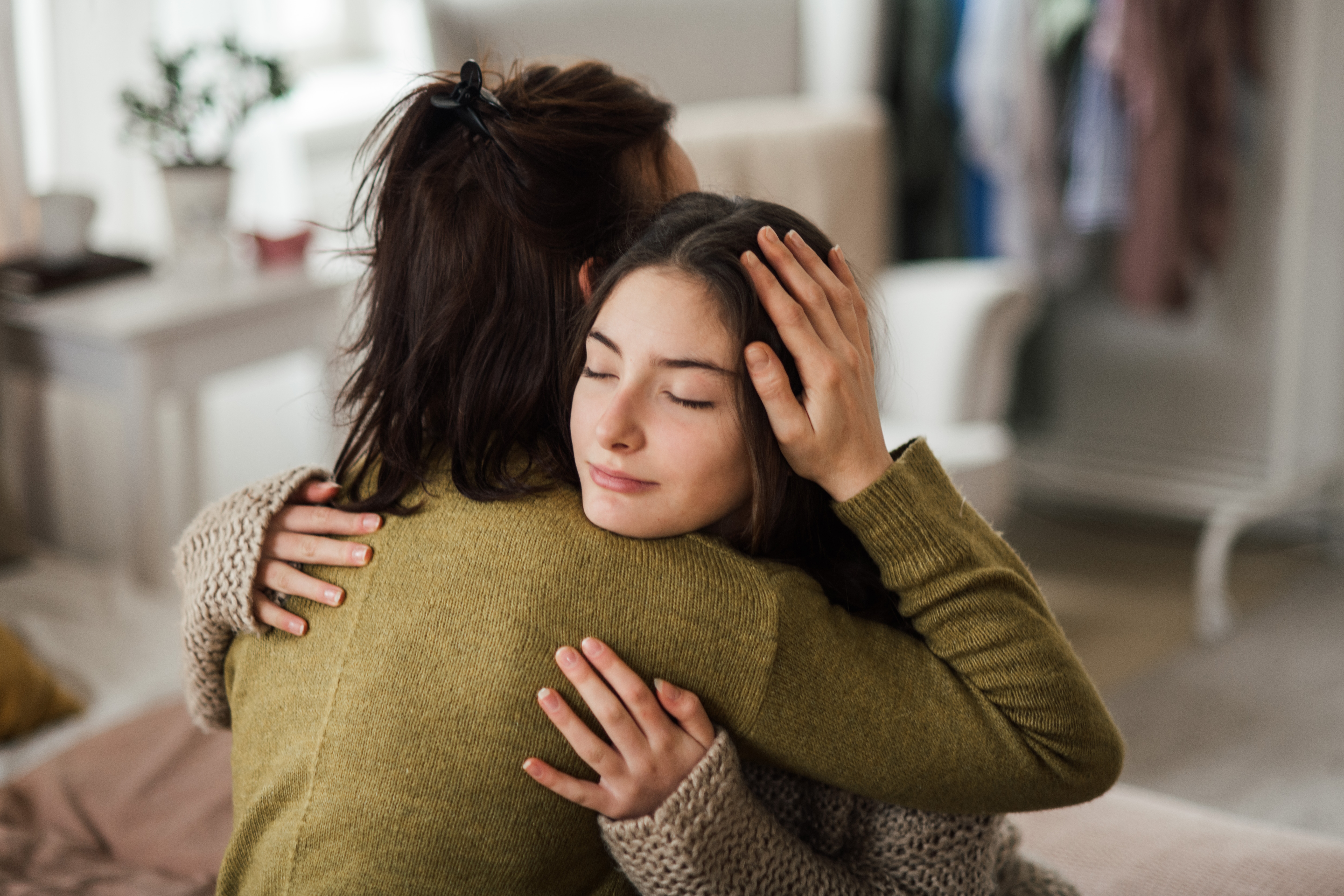 Teenage,Girl,Hugging,Her,Mother,At,Home.